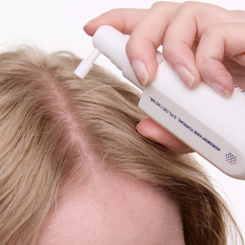 woman using adegen topical formula on hair scalp