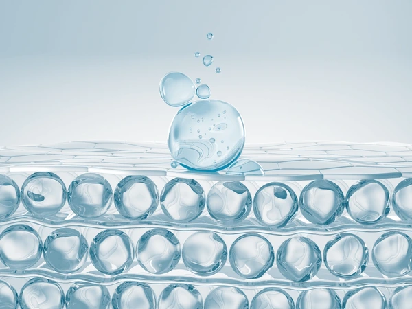 Close-up of water droplets on a textured surface with a light blue gradient background