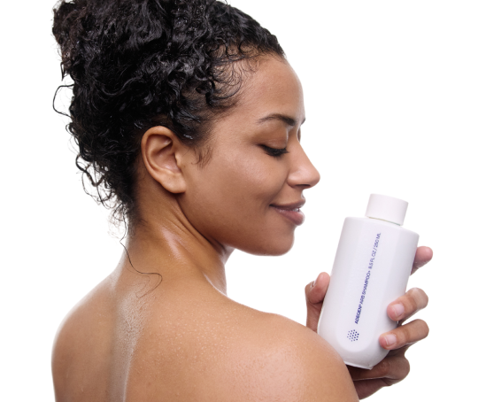 Woman holding a white bottle with a visible brand logo on a white background